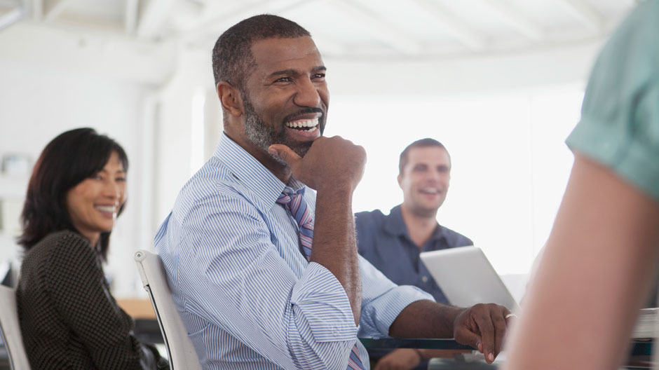 Office workers enjoy a lighter moment around a table during a training session
