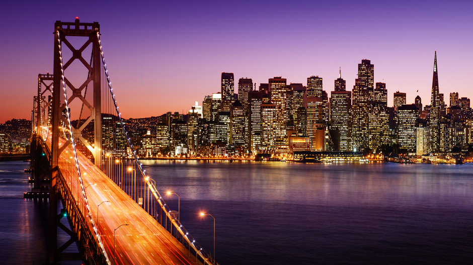 Nighttime view of the San Francisco city skyline with the Golden Gate Bridge in the foreground