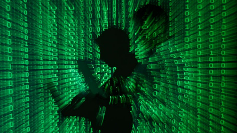 An illustration picture shows a projection of binary code on a man holding a laptop computer, in an office in Warsaw June 24, 2013. 